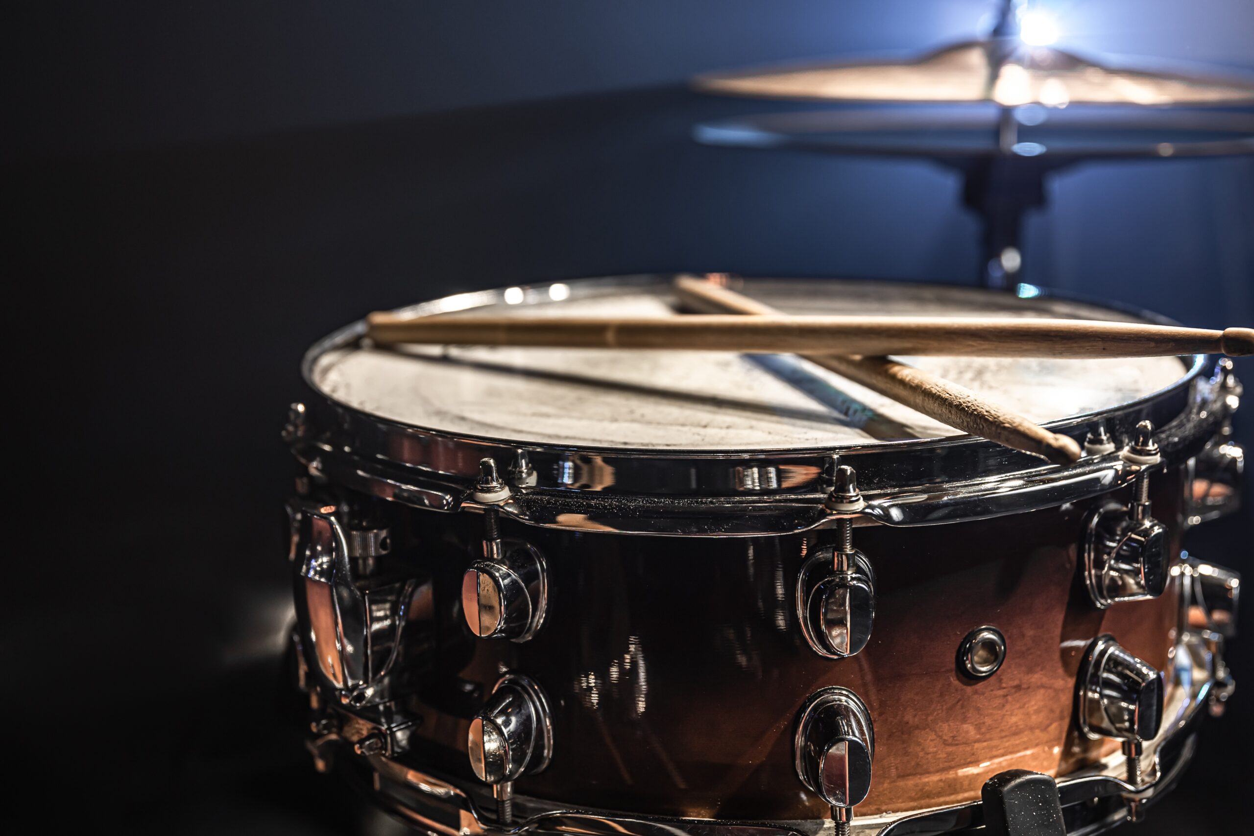 Snare drum, percussion instrument on a dark background with stage lighting.