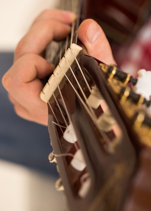 Music, close-up. Musician with a wooden guitar